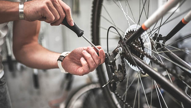 Mechanic repairing bicycle rear wheel